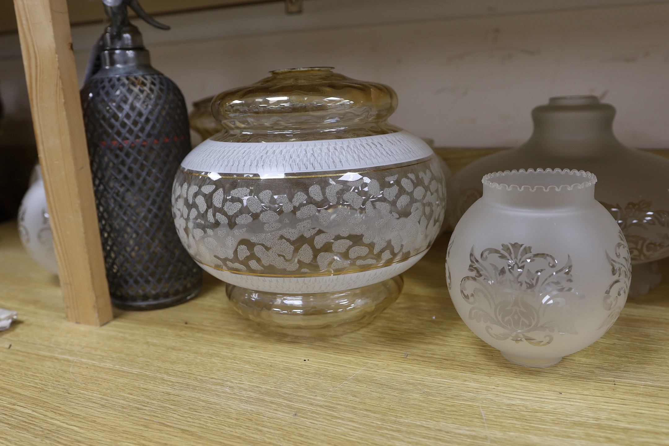 A group of glass lamp shades and an electroplate mounted syphon